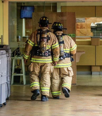 Firefighters moving through a building